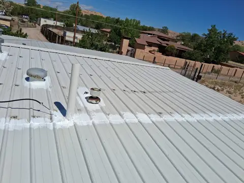 CyJ crew sealing and repairing a metal roof near Espanola, NM