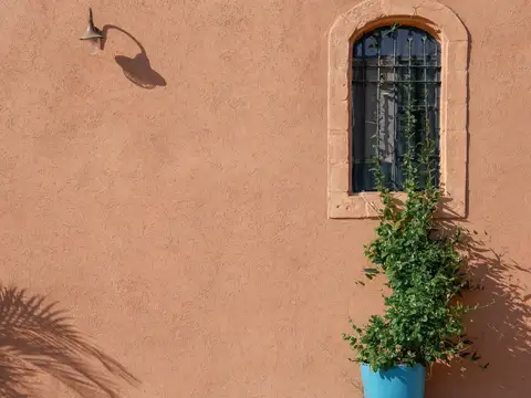 Adobe wall with an arched window in Southwestern architectural style
